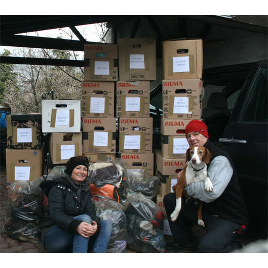 Foto: Claudia und Helmut Böhm mit Boris und den Kisten mit warmer Winterbekleidung, Schuhen, Spielzeug und Rucksäcken für die Kinder in Ungarn.